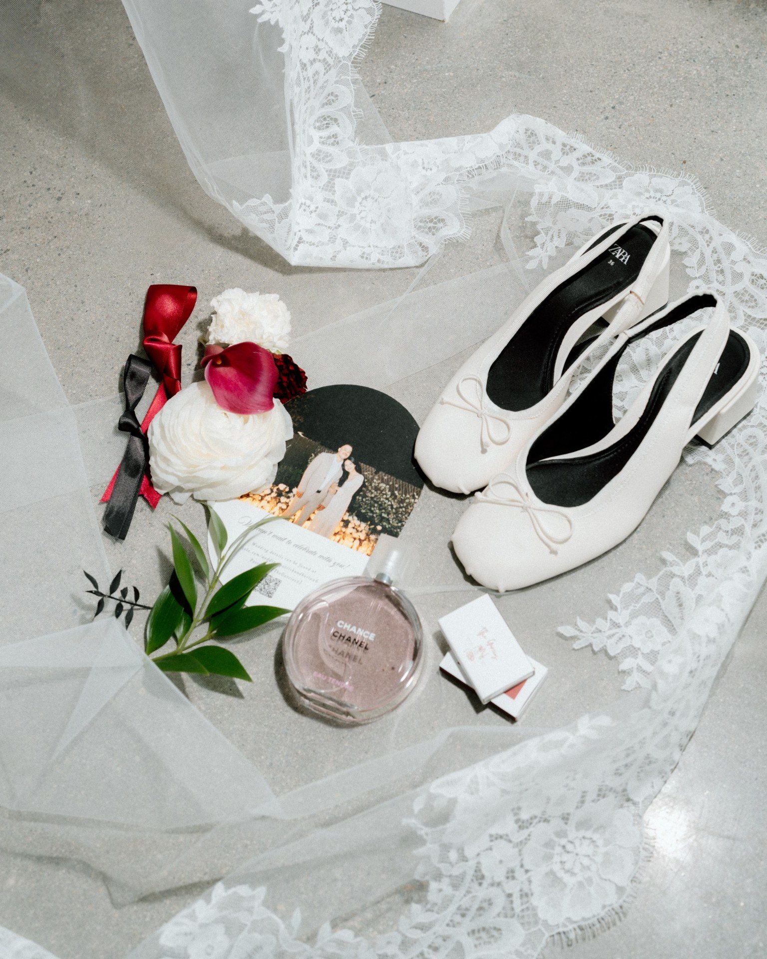 Bridal shoes, perfume, flowers and lace arranged before the ceremony.