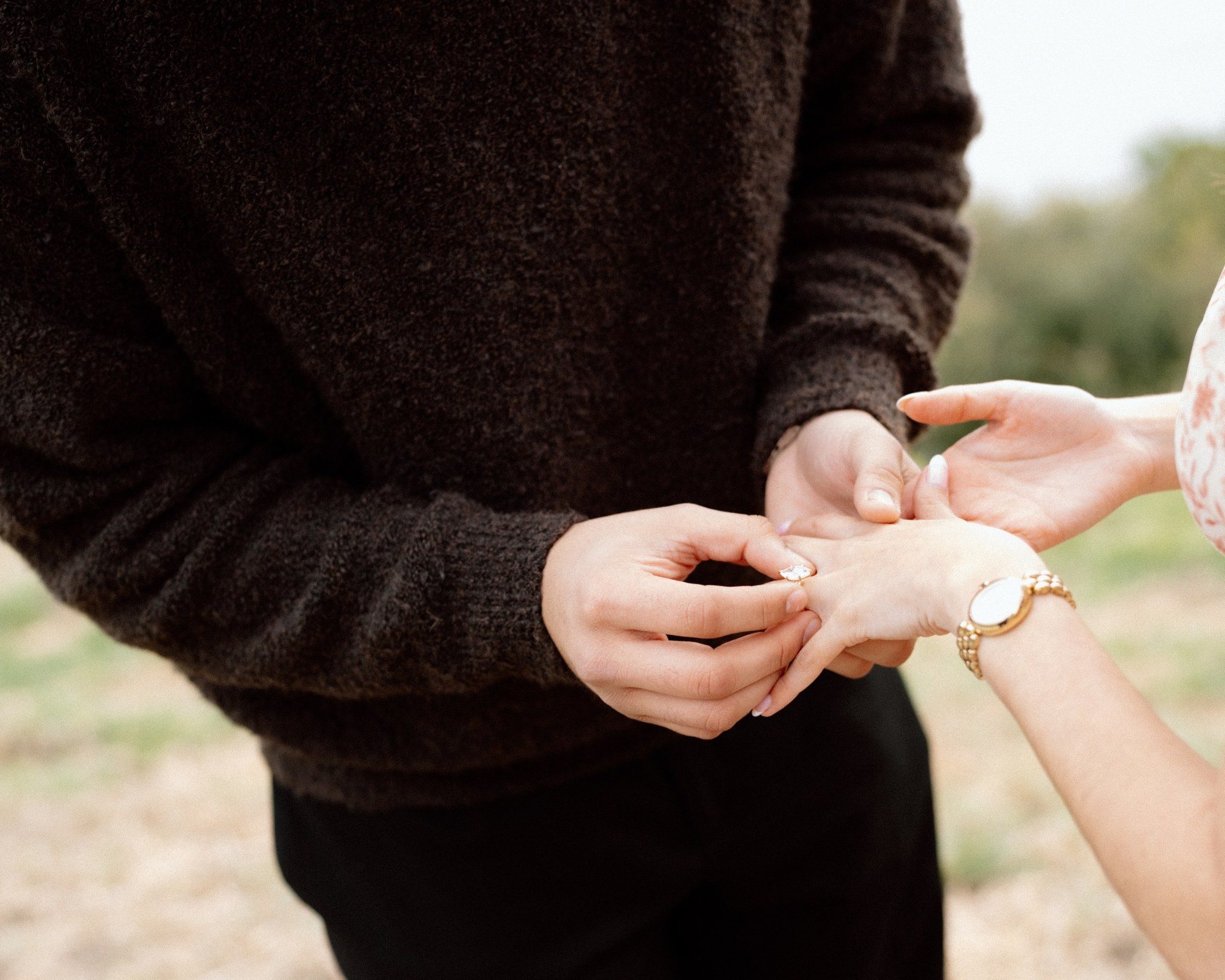 Close-up of a ring being placed on a partner’s hand.